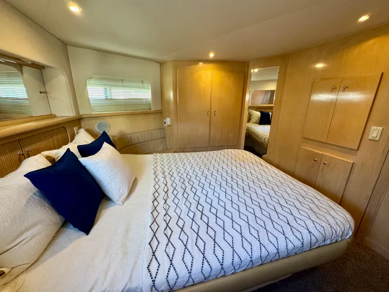 Slide: The Image of Luxurious bedroom in 1997 Carver 405 Aft Cabin Motoryacht with elegant bedding and wood cabinetry. - 33