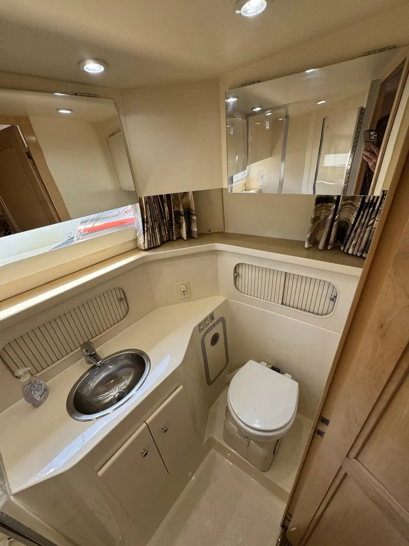 Slide: The Image of 1997 Carver 405 Aft Cabin Motoryacht bathroom with sink, toilet, and mirrored cabinets. - 35