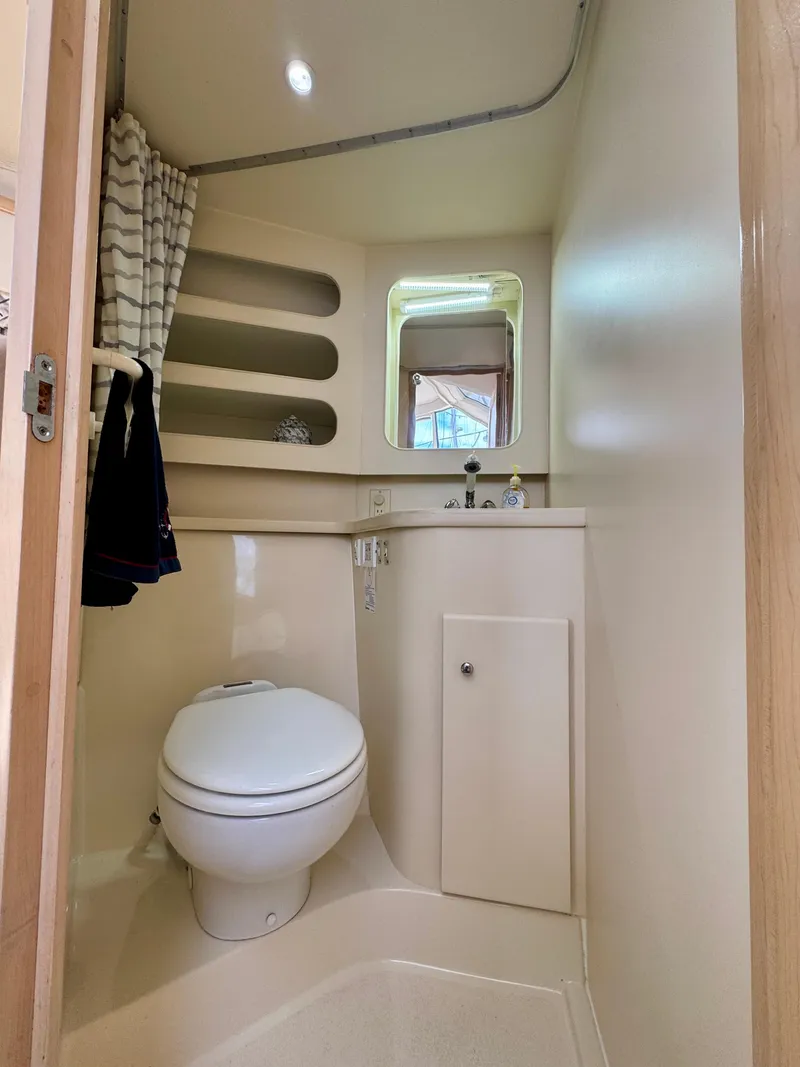 Slide: The Image of 1997 Carver 405 Aft Cabin Motoryacht bathroom with toilet, shelves, and window. - 40