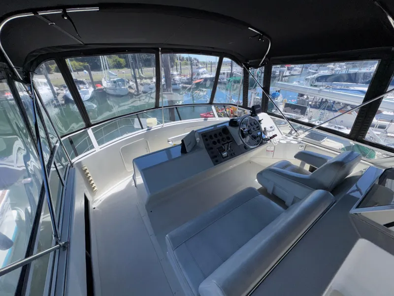 Slide: The Image of 1997 Carver 405 Aft Cabin Motoryacht helm with panoramic marina view. - 8