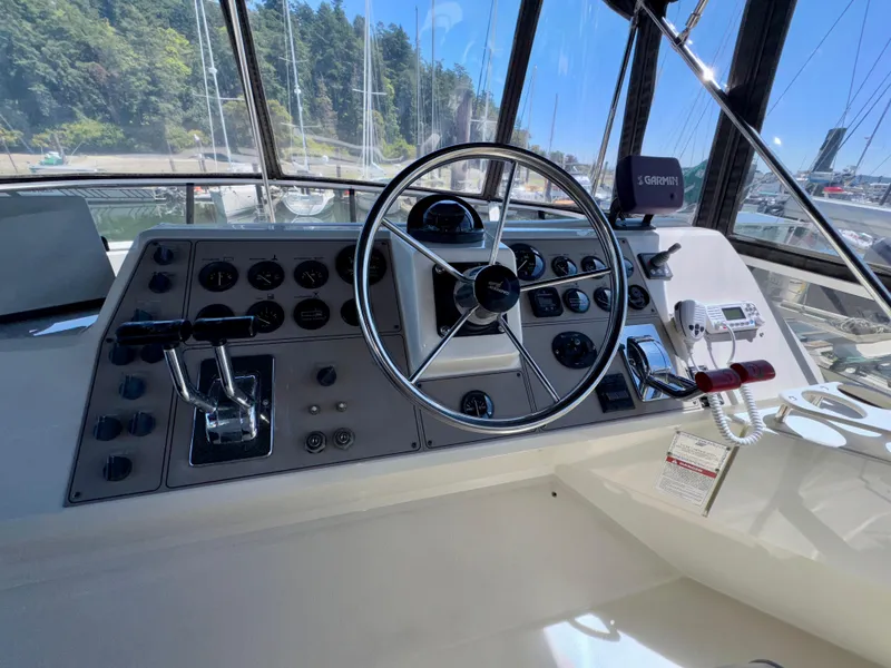 Slide: The Image of 1997 Carver 405 Aft Cabin Motoryacht helm with steering wheel, controls, and navigation equipment. - 9