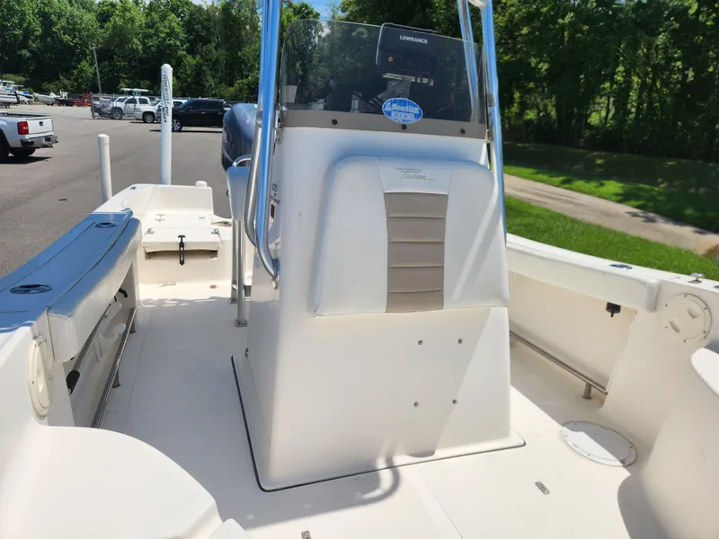 Slide: The Image of 2009 Pioneer 220 Bay Sport boat interior with console and seating, parked outdoors. - 10