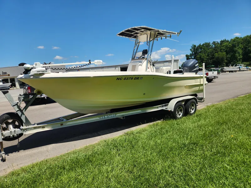 Slide: The Image of 2009 Pioneer 220 Bay Sport boat on trailer, parked outdoors under clear blue sky. - 7