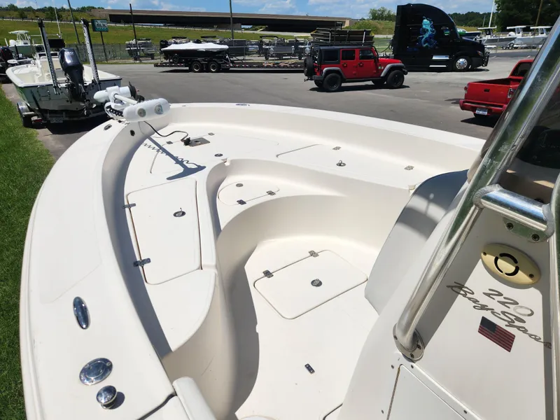 Slide: The Image of 2009 Pioneer 220 Bay Sport boat in parking lot, featuring spacious deck and storage compartments. - 8