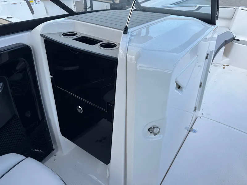 Slide: The Image of 2025 Yamaha Boats AR250 interior with storage compartment and cup holders. - 12