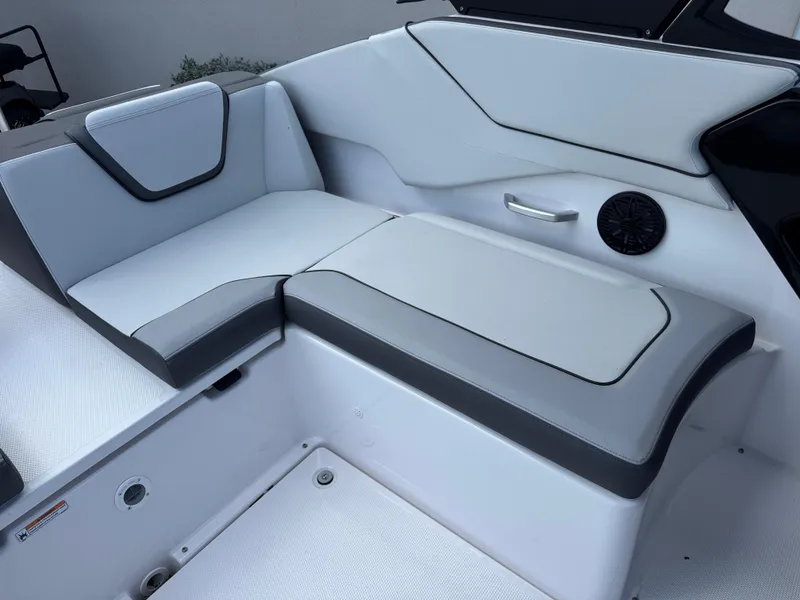 Slide: The Image of 2025 Yamaha AR250 boat interior seating with sleek white and gray upholstery. - 14