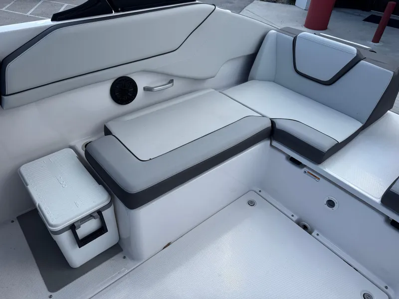 Slide: The Image of 2025 Yamaha Boats AR250 interior seating with cooler and speaker. - 16