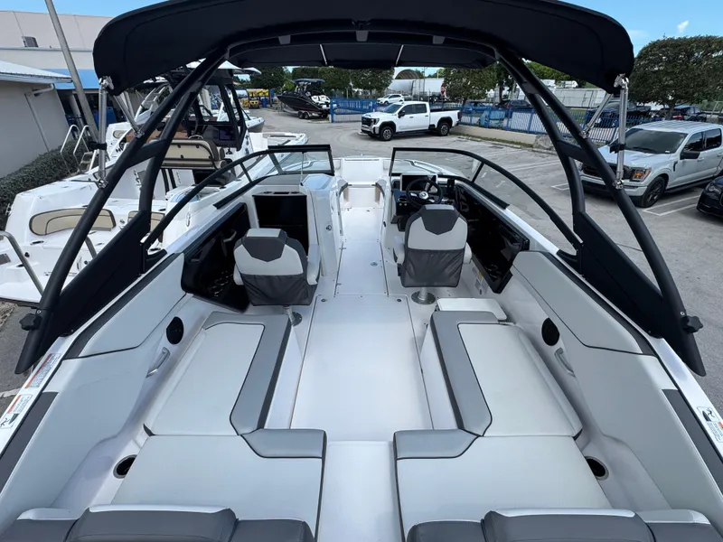 Slide: The Image of 2025 Yamaha Boats AR250 interior with seating, steering wheel, and canopy in a showroom setting. - 3