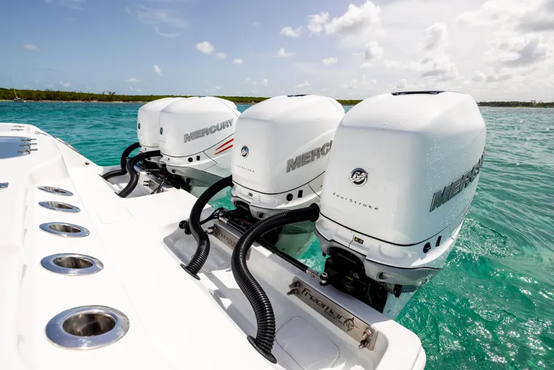Slide: The Image of Triple Mercury outboard engines on a 2022 Freeman 37 VH boat in turquoise waters. - 19