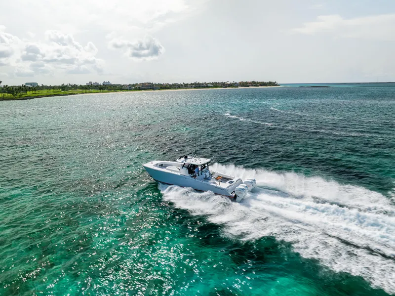 Slide: The Image of A 2022 Freeman 37 VH boat cruising on clear turquoise waters near a lush coastline. - 3
