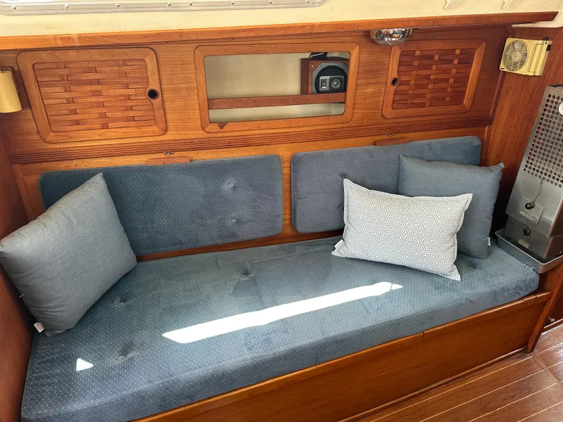 Slide: The Image of Interior of 1985 Sabre 34 MKI sailboat with blue cushioned seating and wooden paneling. - 19