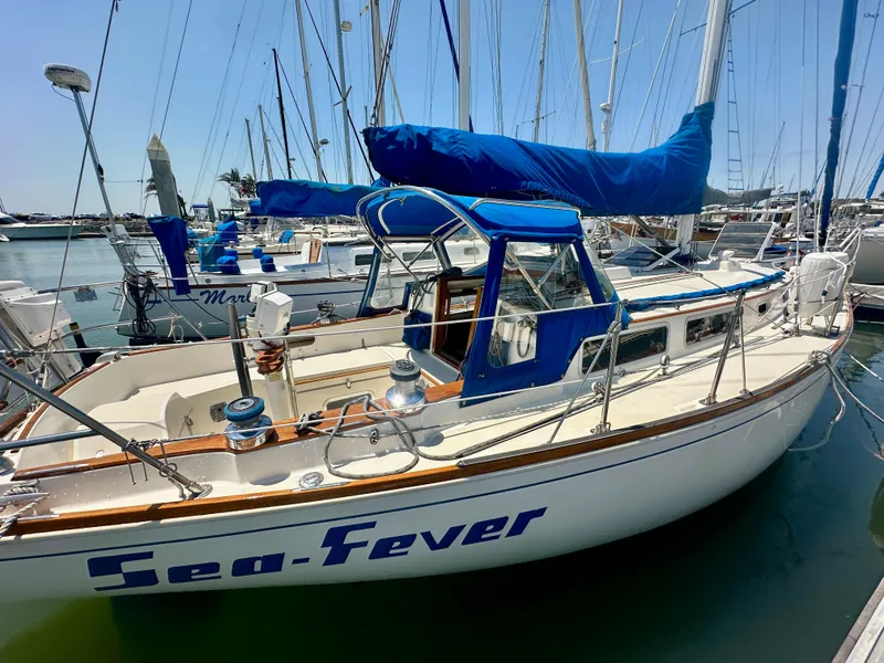 Slide: The Image of 1985 Sabre 34 MKI sailboat "Sea-Fever" docked in a marina, featuring blue covers. - 2
