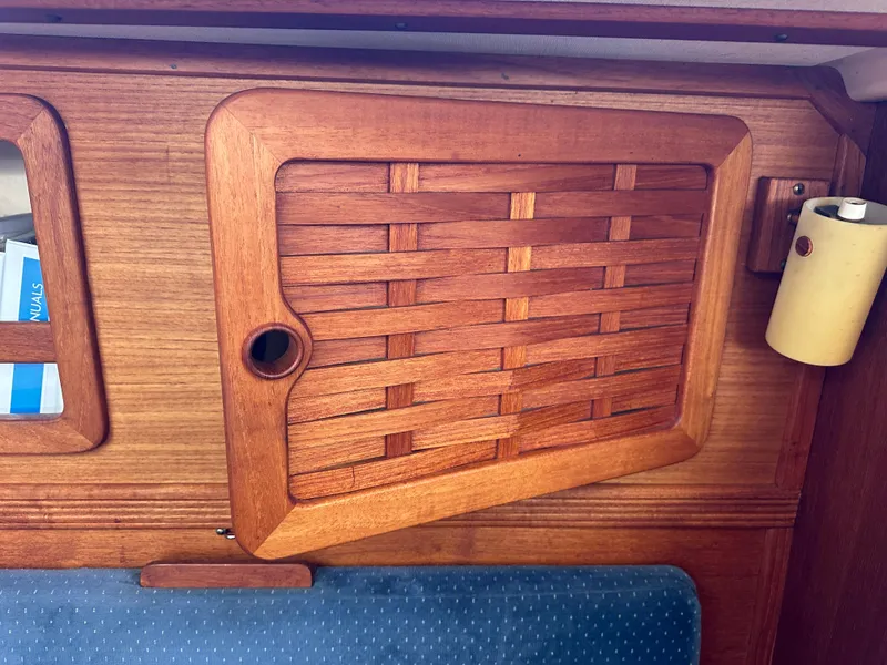 Slide: The Image of Wooden interior detail of a 1985 Sabre 34 MKI sailboat, featuring a woven cabinet door. - 20