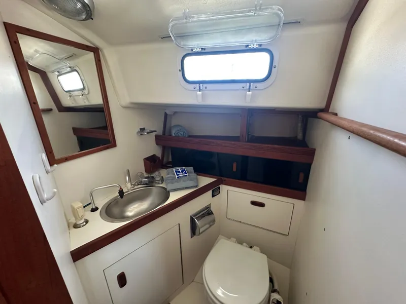 Slide: The Image of 1985 Sabre 34 MKI yacht bathroom with sink, mirror, and porthole window. - 28