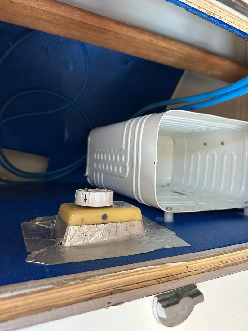 Slide: The Image of Interior detail of a 1985 Sabre 34 MKI sailboat, featuring a storage area with a knob and container. - 41