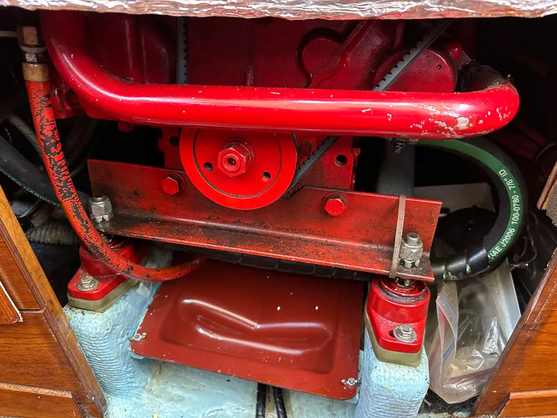Slide: The Image of Engine compartment of a 1985 Sabre 34 MKI sailboat, featuring red mechanical components. - 42