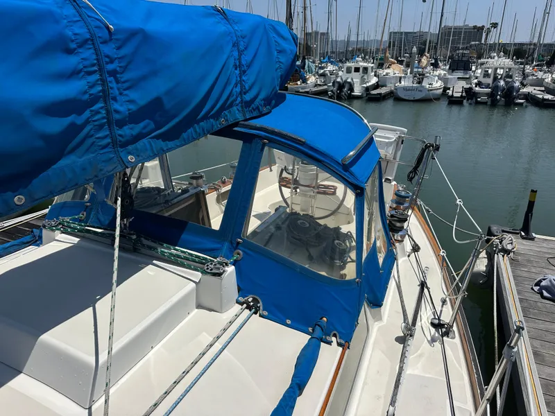 Slide: The Image of 1985 Sabre 34 MKI sailboat with blue canvas cover docked at marina. - 6