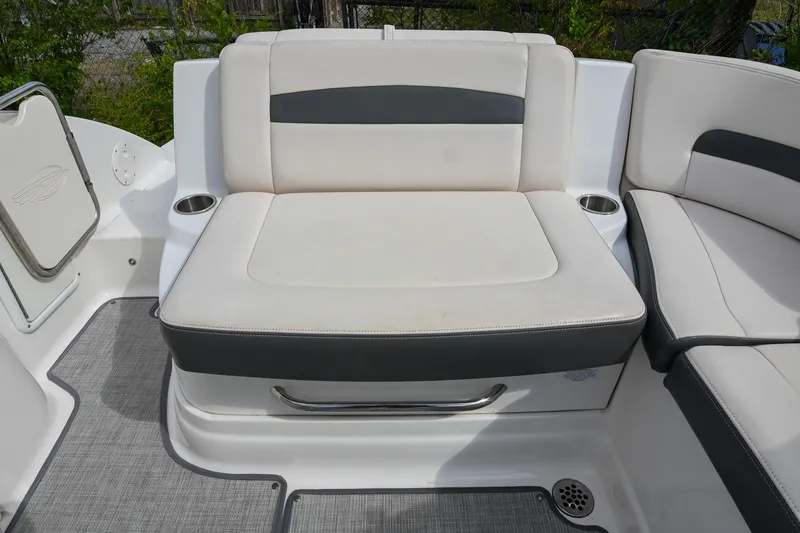 Slide: The Image of 2018 Chaparral 264 Sunesta boat seating area with cup holders and cushioned seats. - 16