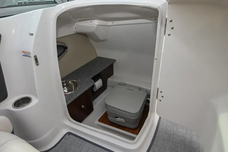 Slide: The Image of 2018 Chaparral 264 Sunesta boat interior with compact bathroom and sink. - 22