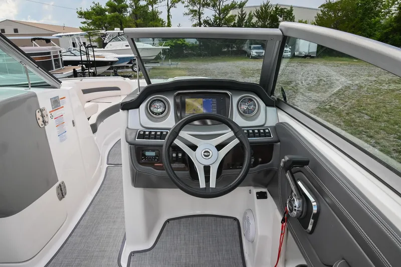 Slide: The Image of 2018 Chaparral 264 Sunesta boat dashboard with steering wheel and navigation display. - 25