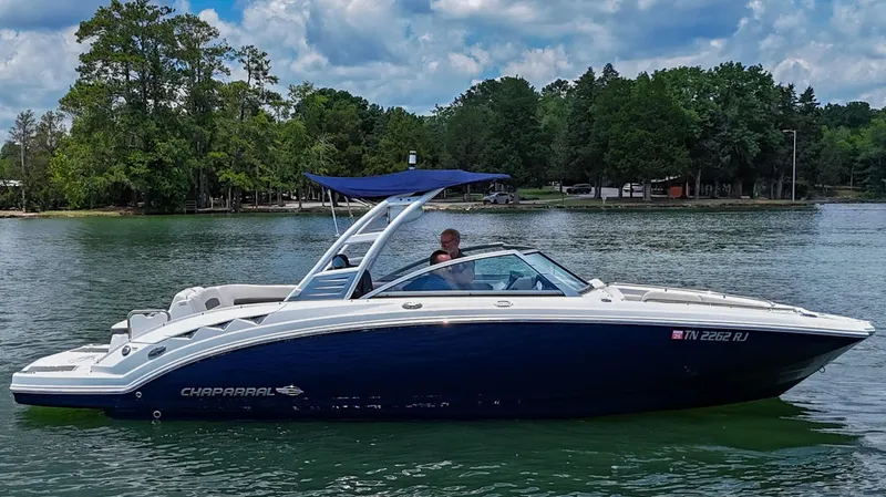 Slide: The Image of 2018 Chaparral 264 Sunesta boat on a lake with lush green trees. - 36