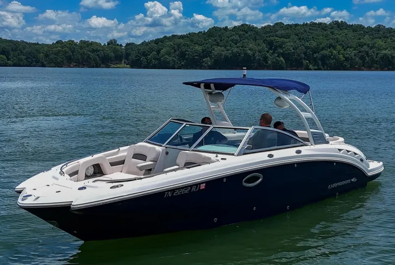 Slide: The Image of 2018 Chaparral 264 Sunesta boat on a lake with blue canopy and passengers. - 37