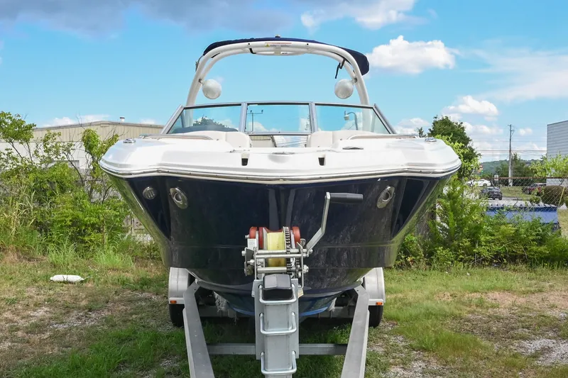 Slide: The Image of 2018 Chaparral 264 Sunesta boat on trailer, parked outdoors under a blue sky. - 5