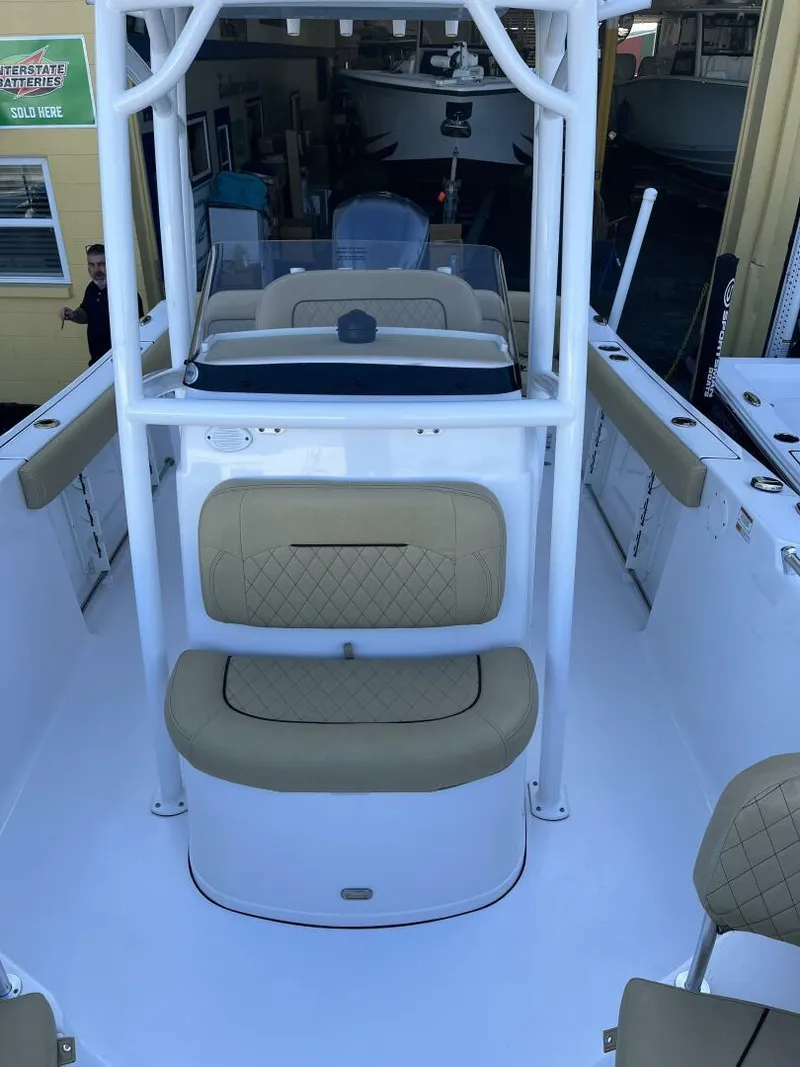 Slide: The Image of 2021 Sportsman 231 Heritage boat interior with beige seating and white framework. - 9