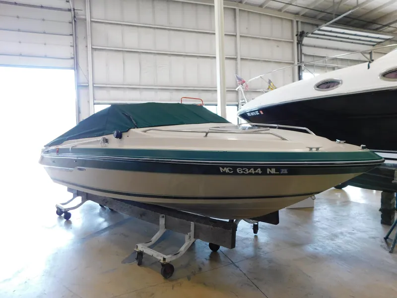 The Image of 1989 Sea Ray 20 CUDDY boat with green cover in indoor storage. - 1
