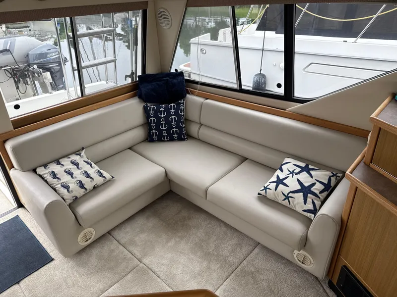Slide: The Image of Luxurious interior of 2001 Bayliner 3988 Command Bridge Motoryacht with plush seating and nautical-themed pillows. - 12