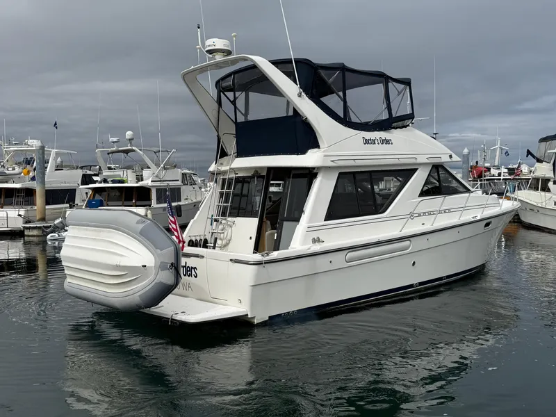 Slide: The Image of 2001 Bayliner 3988 Command Bridge Motoryacht docked in a marina, overcast sky. - 2