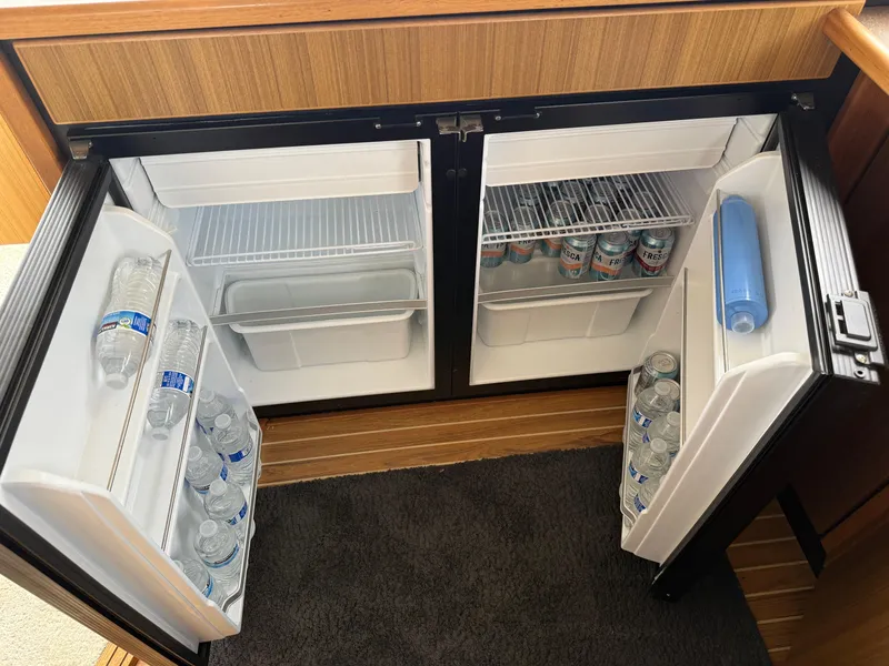 Slide: The Image of Mini fridge stocked with water bottles and soda cans on a 2001 Bayliner 3988 Command Bridge Motoryacht. - 21