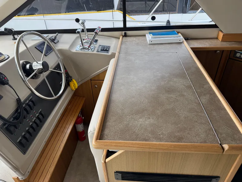 Slide: The Image of 2001 Bayliner 3988 Command Bridge Motoryacht helm with steering wheel and control panel. - 24