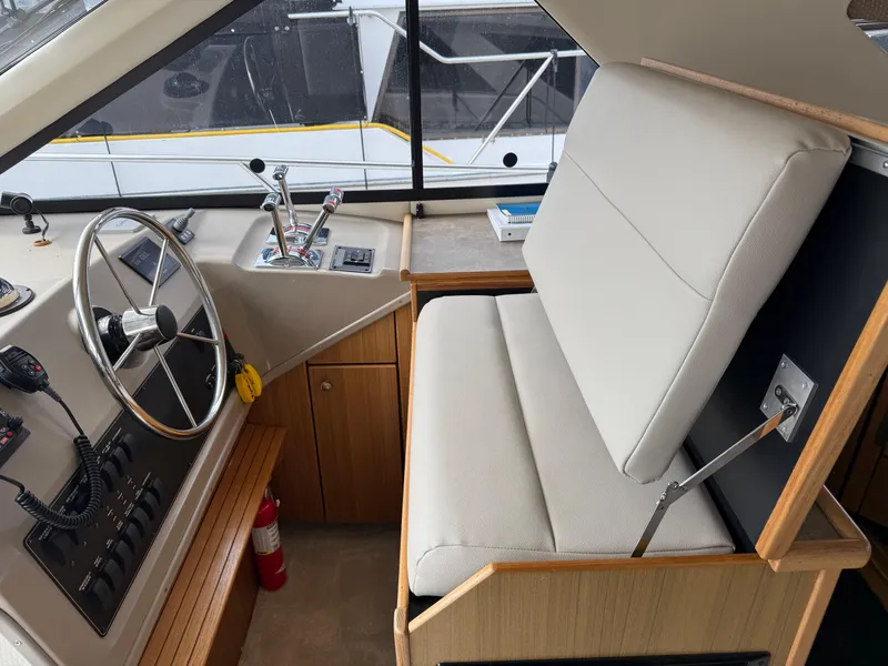 Slide: The Image of 2001 Bayliner 3988 Command Bridge Motoryacht helm with steering wheel and control panel. - 25