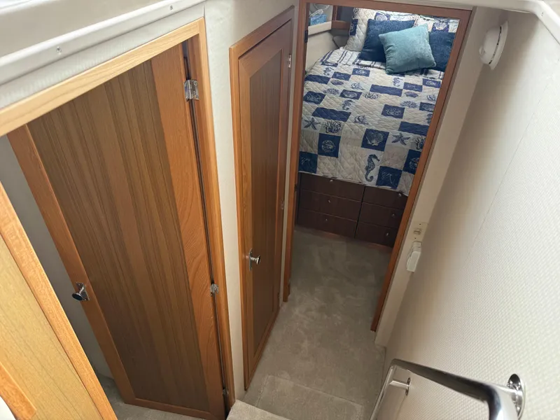 Slide: The Image of Interior of 2001 Bayliner 3988 Command Bridge Motoryacht, featuring cozy bedroom and wooden doors. - 27