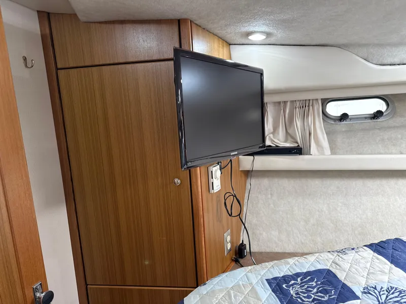Slide: The Image of Interior of 2001 Bayliner 3988 yacht with TV, wood paneling, and porthole window. - 29