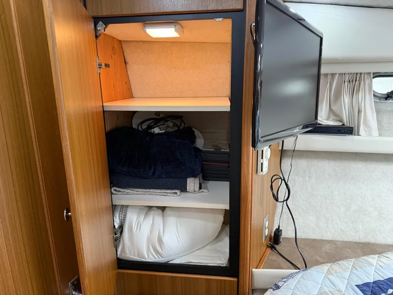 Slide: The Image of Interior of 2001 Bayliner 3988 yacht showing storage cabinet and mounted TV. - 30