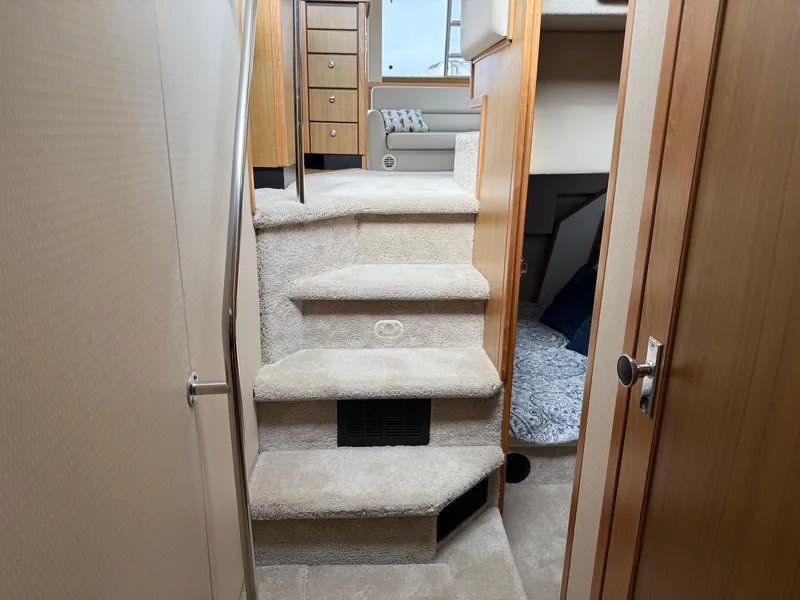 Slide: The Image of Interior view of 2001 Bayliner 3988 Command Bridge Motoryacht, featuring carpeted stairs and wooden cabinetry. - 35