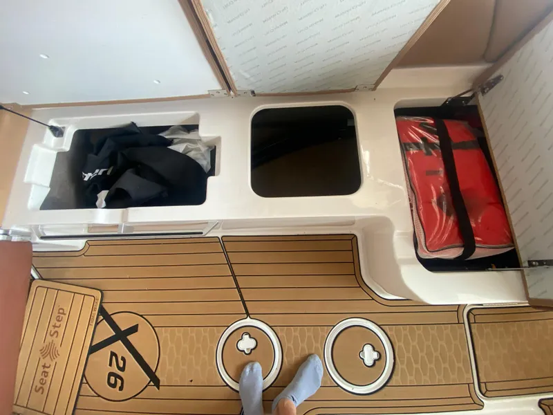 Slide: The Image of 2022 MasterCraft X26 boat storage compartments with life jackets and gear. - 21