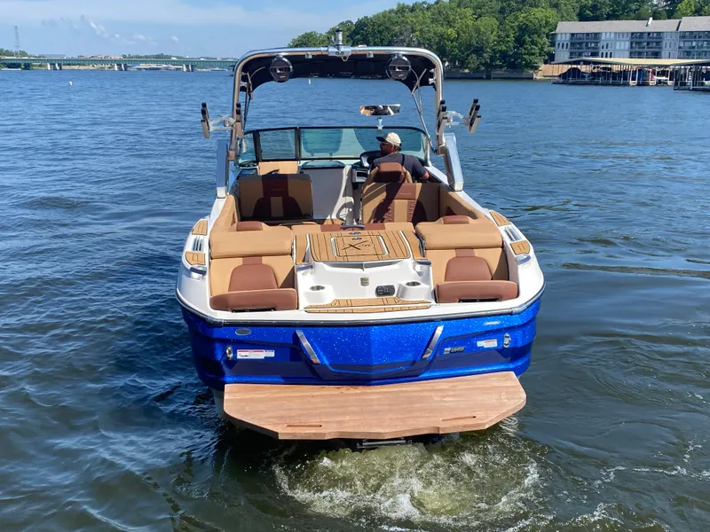 Slide: The Image of 2022 MasterCraft X26 boat on a lake, featuring luxurious seating and sleek design. - 3