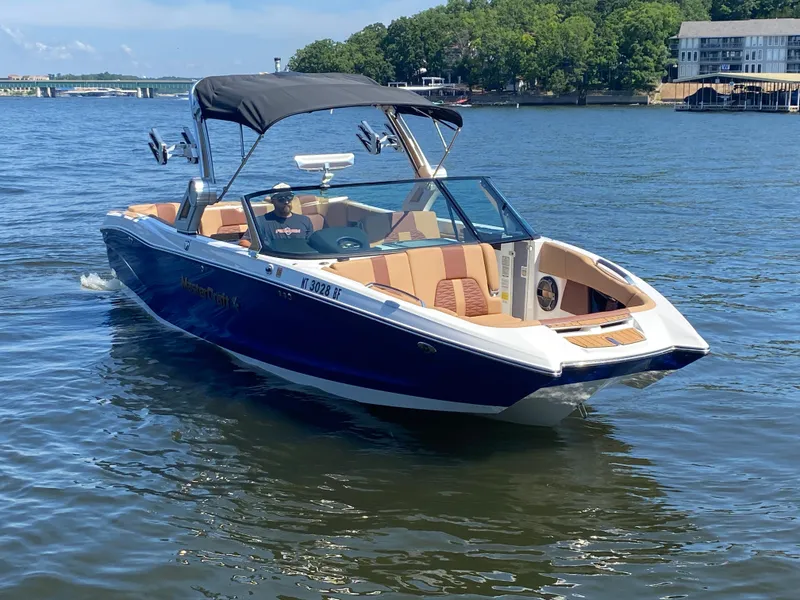 Slide: The Image of 2022 MasterCraft X26 boat cruising on a lake with a canopy and luxurious seating. - 4