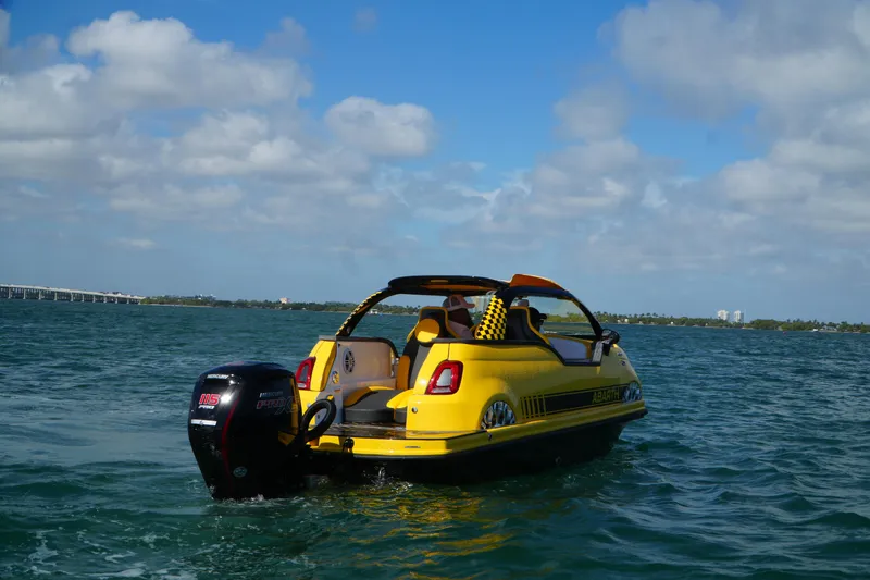 Slide: The Image of Yellow Fiat 500 Abarth boat hybrid on water, 2025 model, clear sky background. - 11