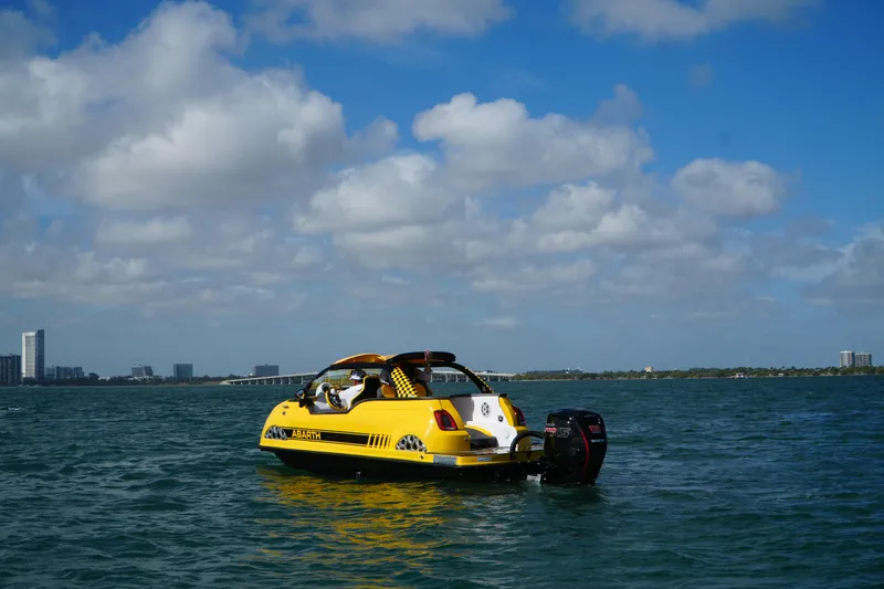 Slide: The Image of 2025 Car Off-shore Fiat 500 Abarth boat on water under blue sky. - 12