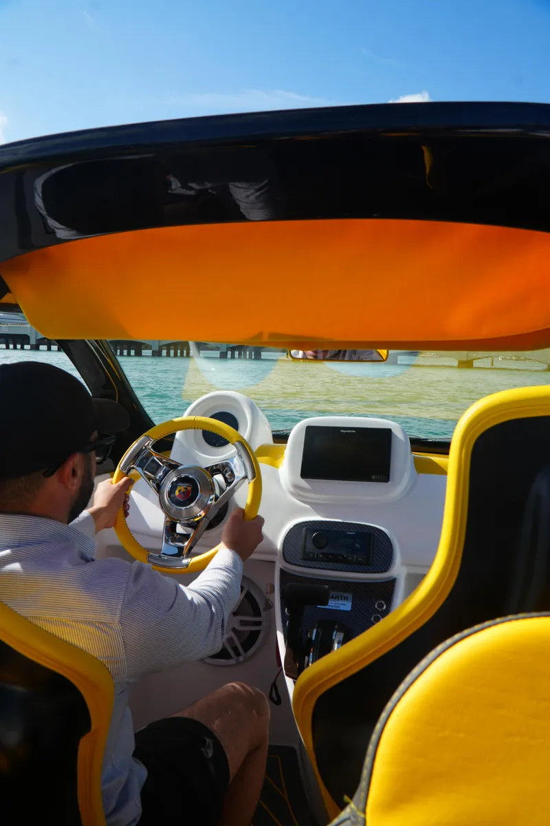Slide: The Image of 2025 Car Off-shore Fiat 500 Abarth interior with yellow accents, steering wheel, and dashboard. - 24