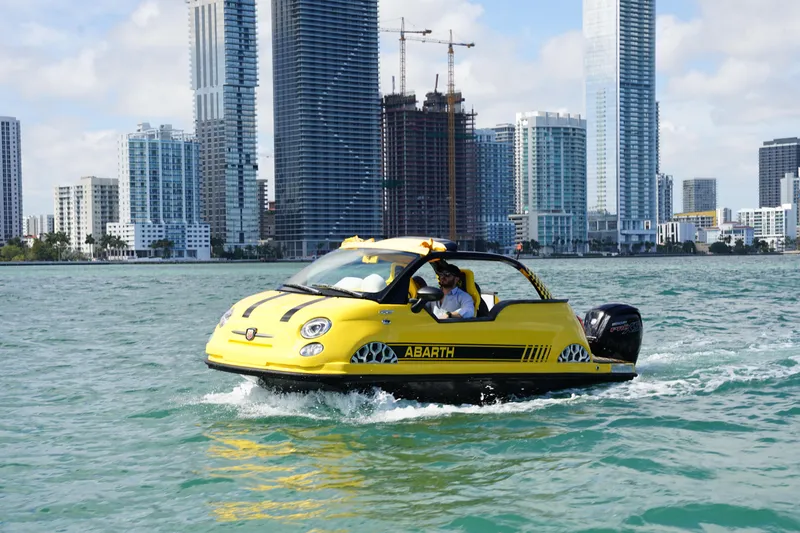 Slide: The Image of 2025 Car Off-shore Fiat 500 Abarth boat on water with city skyline background. - 7