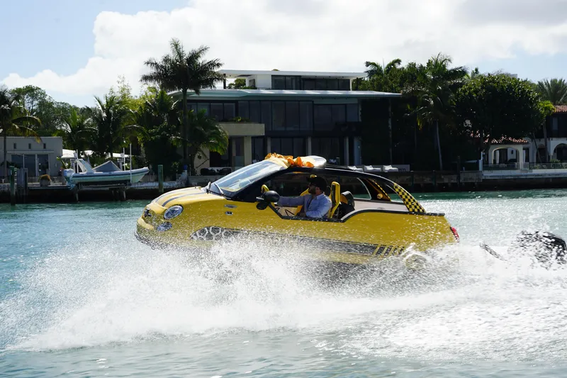 Slide: The Image of 2025 Car Off-shore Fiat 500 Abarth driving on water near modern waterfront homes. - 8