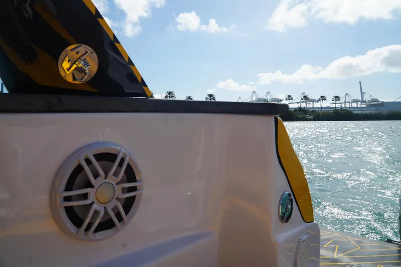 Slide: The Image of Fiat 500 Abarth 2025 on water, sunny day, palm trees in background. - 19