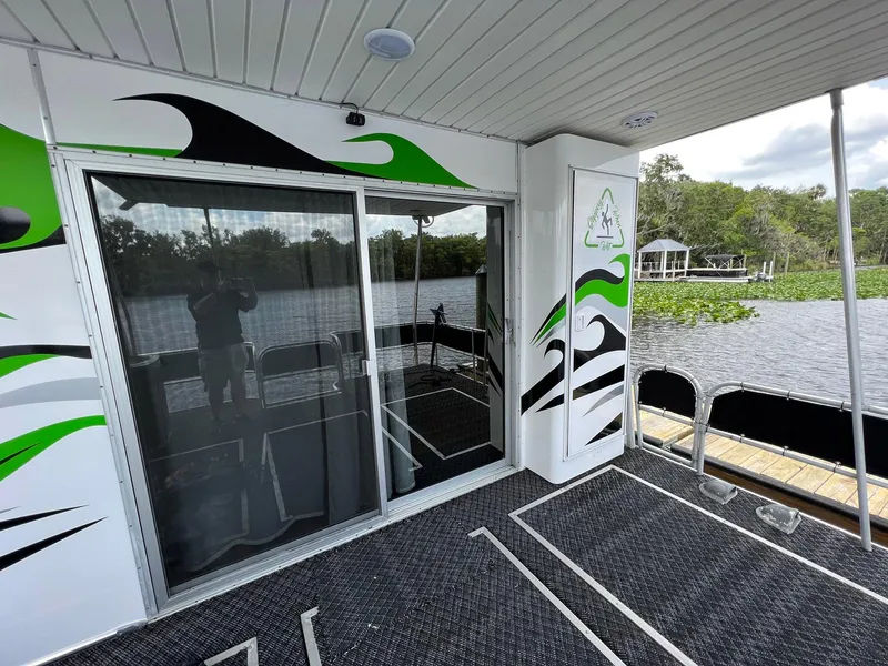 Slide: The Image of 1989 Sumerset Houseboat 64' x 14' with modern design, docked on a serene lake. - 16