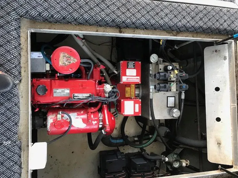 Slide: The Image of Engine compartment of a 1989 Sumerset Houseboat 64' x 14', featuring red machinery and components. - 17