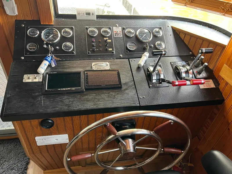 Slide: The Image of Control panel of a 1989 Sumerset Houseboat, featuring gauges, levers, and a steering wheel. - 4